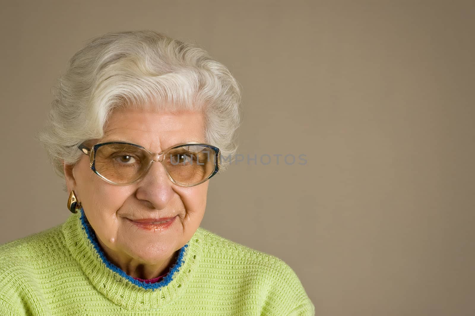 Senior lady portrait, smiling, with glasses, with copy space.