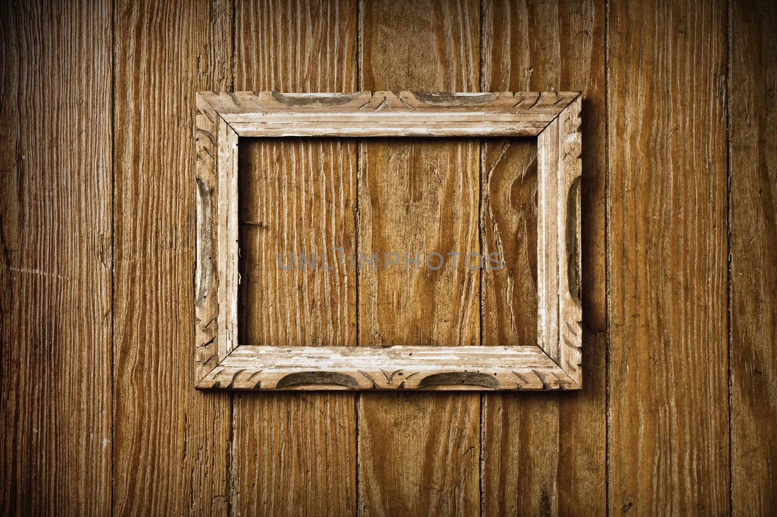 Blank vintage picture frame on a wooden wall.