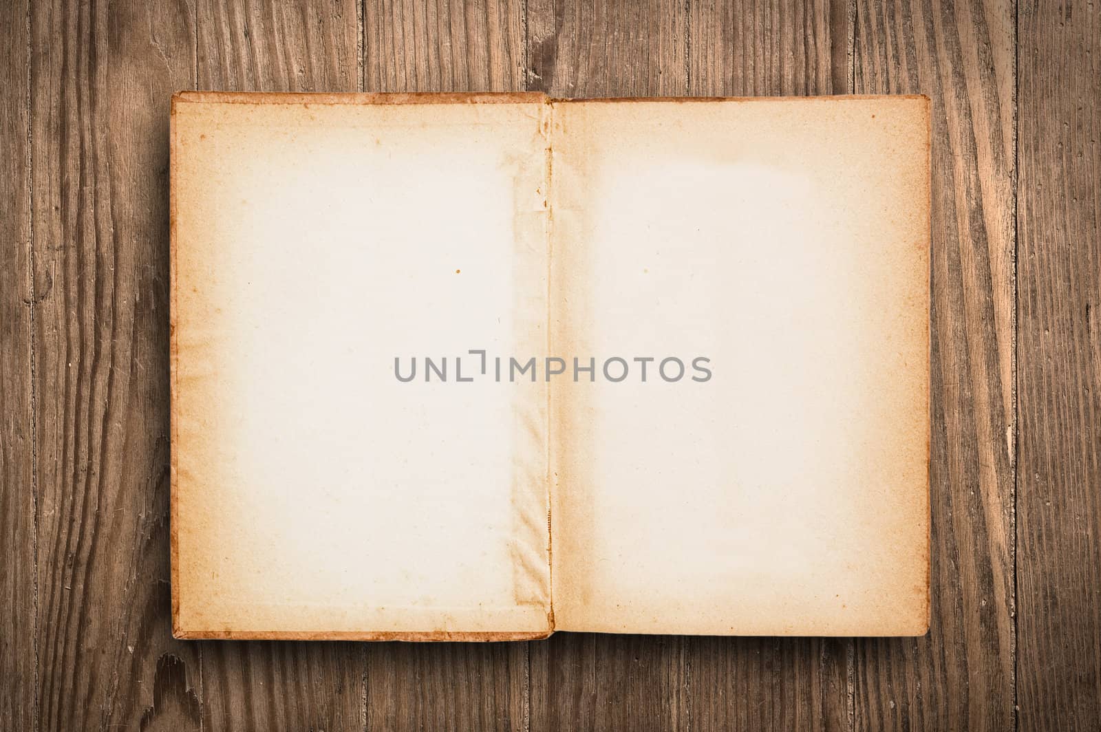 Vintage book, open, on old wooden table.
