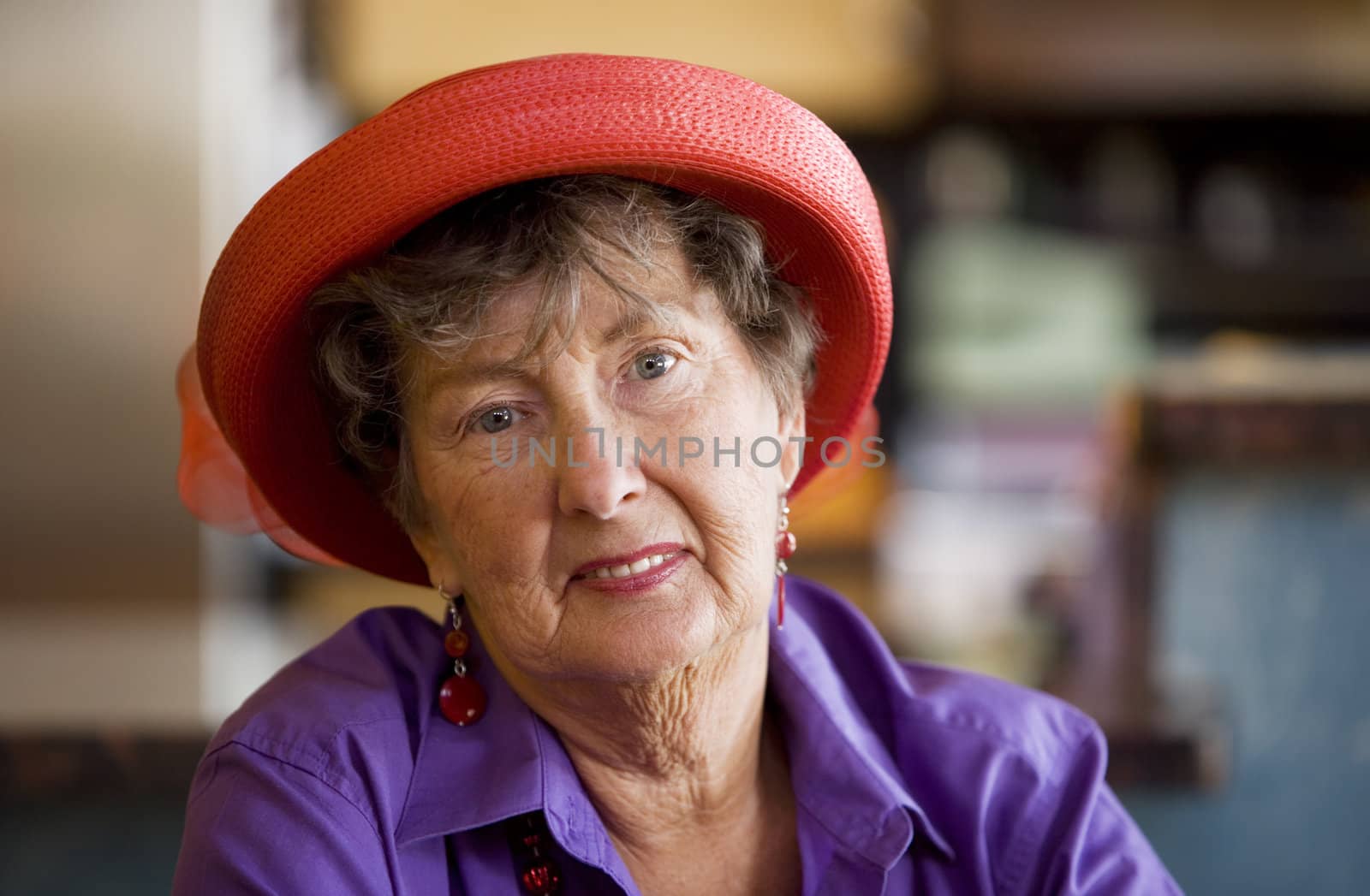 Friendly senior woman wearing a red hat