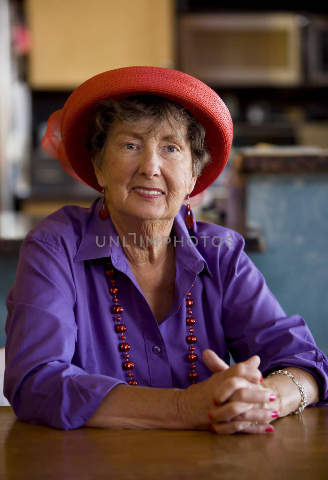 Friendly senior woman wearing a red hat