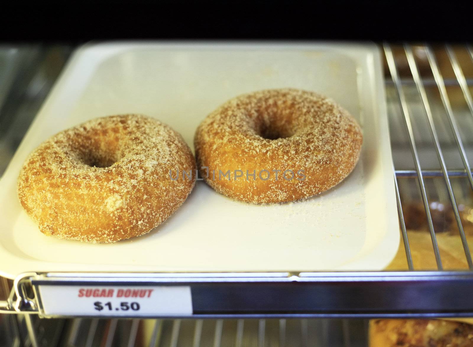 Two doughnuts on a tray in a show-window with the price