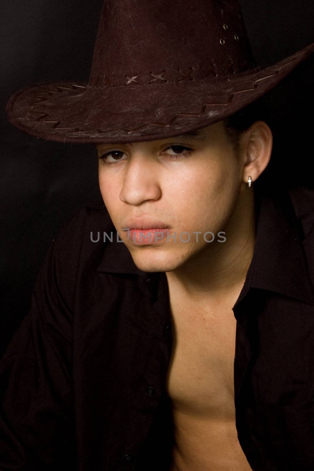 sexy aruban male wearing a western hat on black