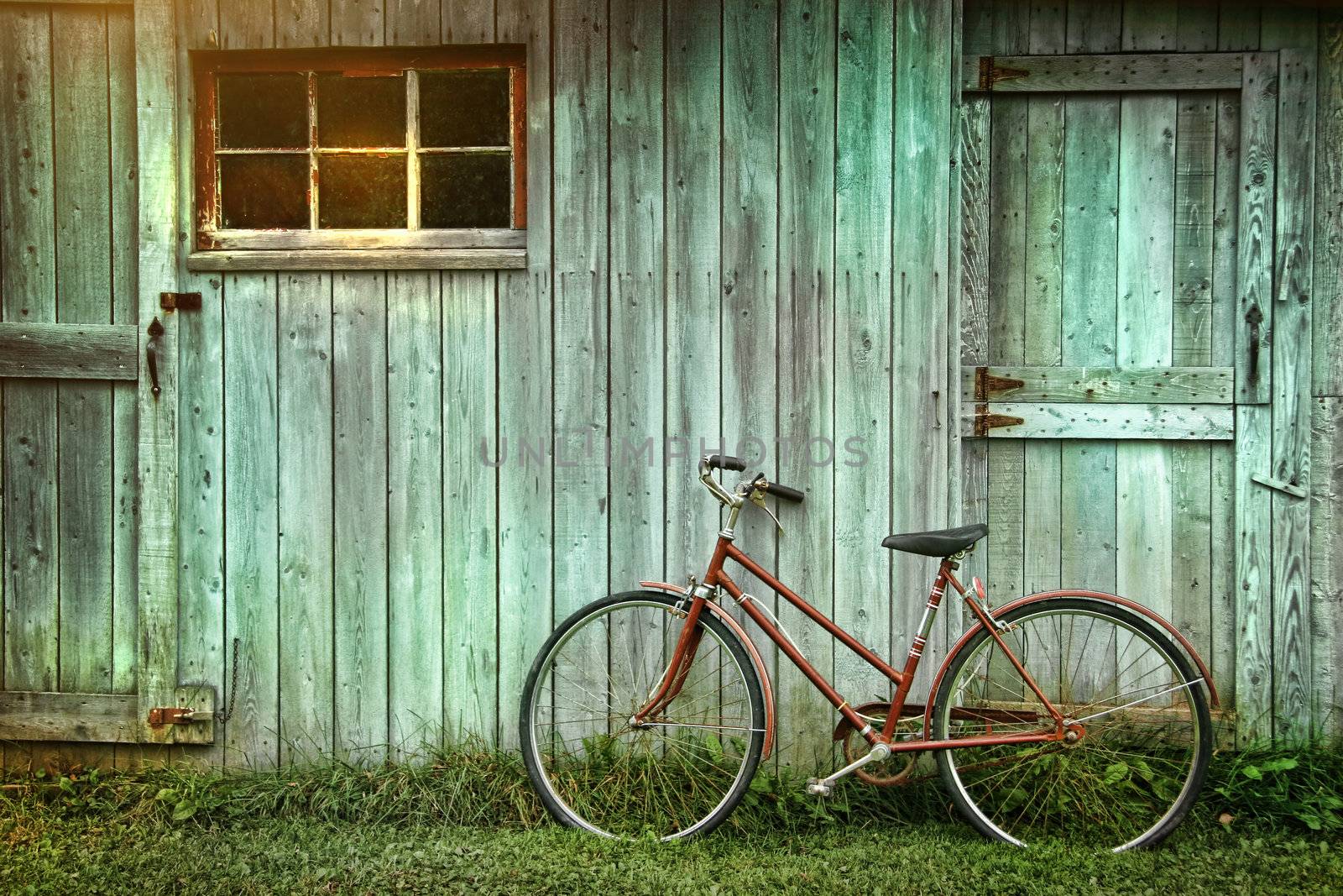 Old bicycle leaning against grungy barn by Sandralise