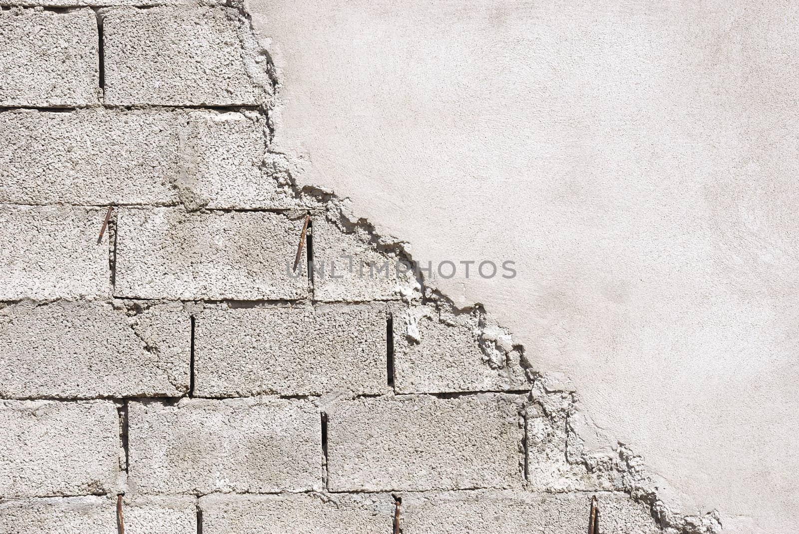 Unfinished wall made of concrete blocks covered with mortar.