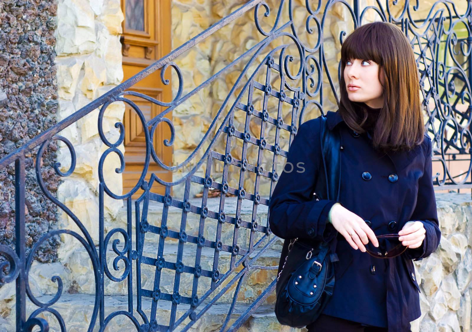 beautiful brunette near grating entrance of building