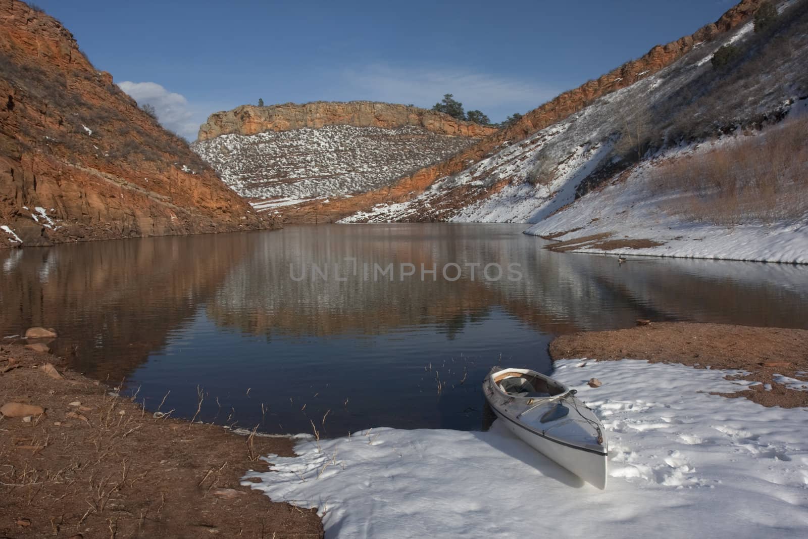 canoe and Colorado mountain lake in early spring by PixelsAway