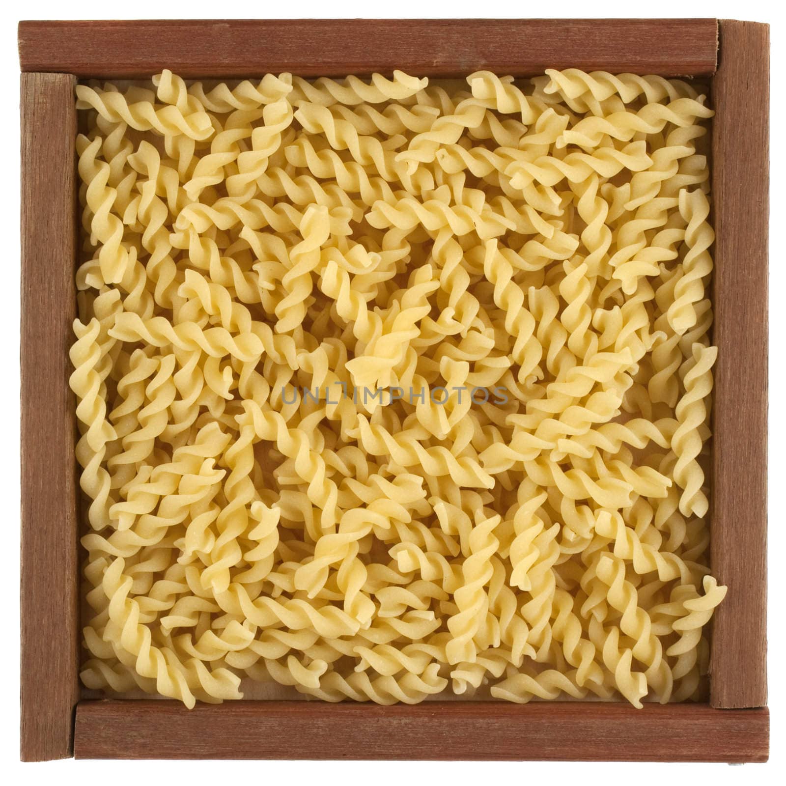 uncooked fusilli pasta in wooden box by PixelsAway