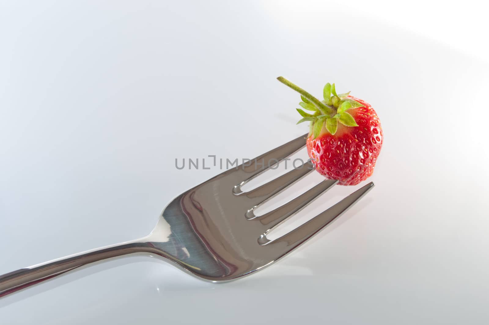 Single strawberry on a fork.