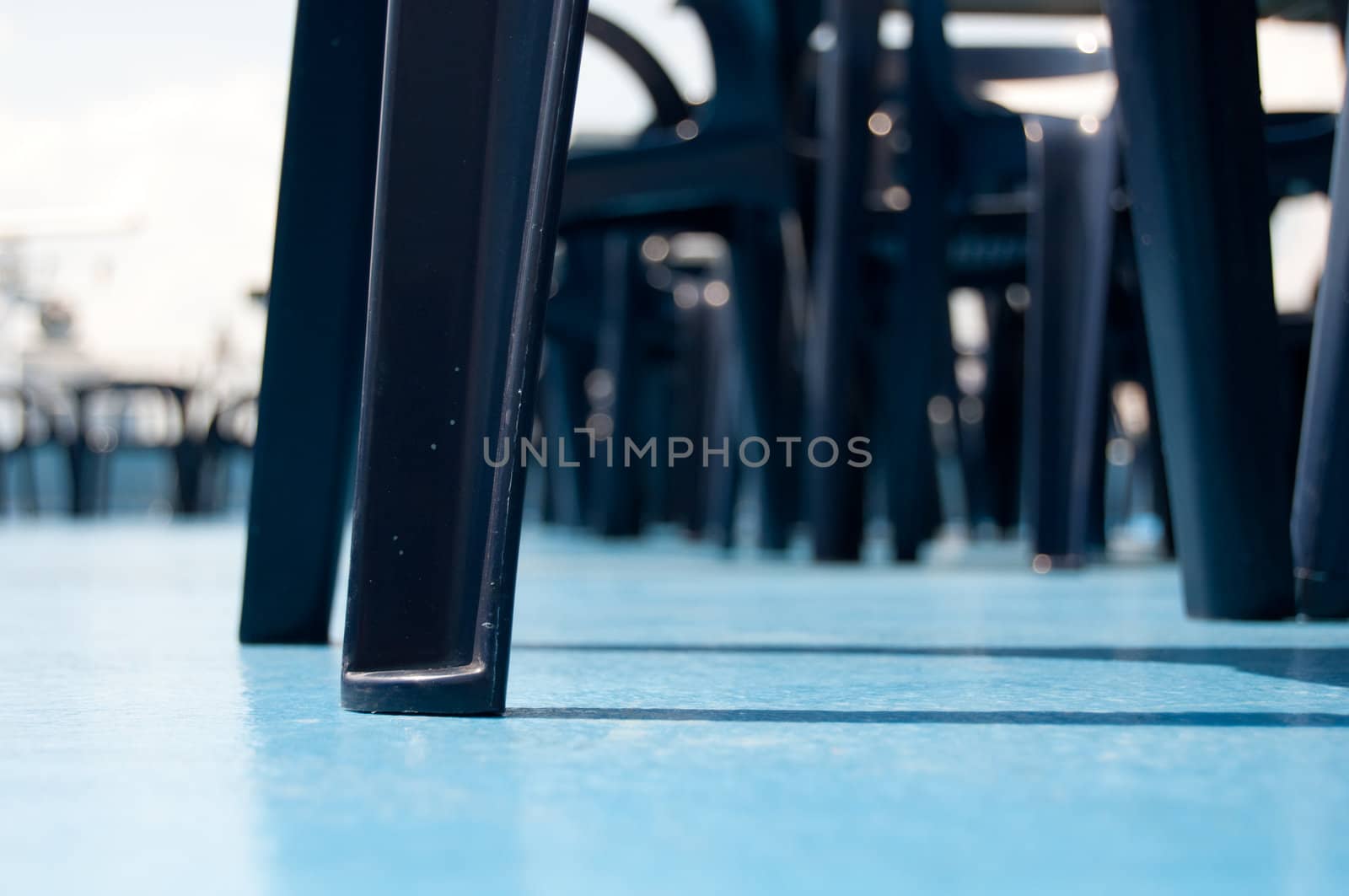 Chairs on a deck with a blue ground.
