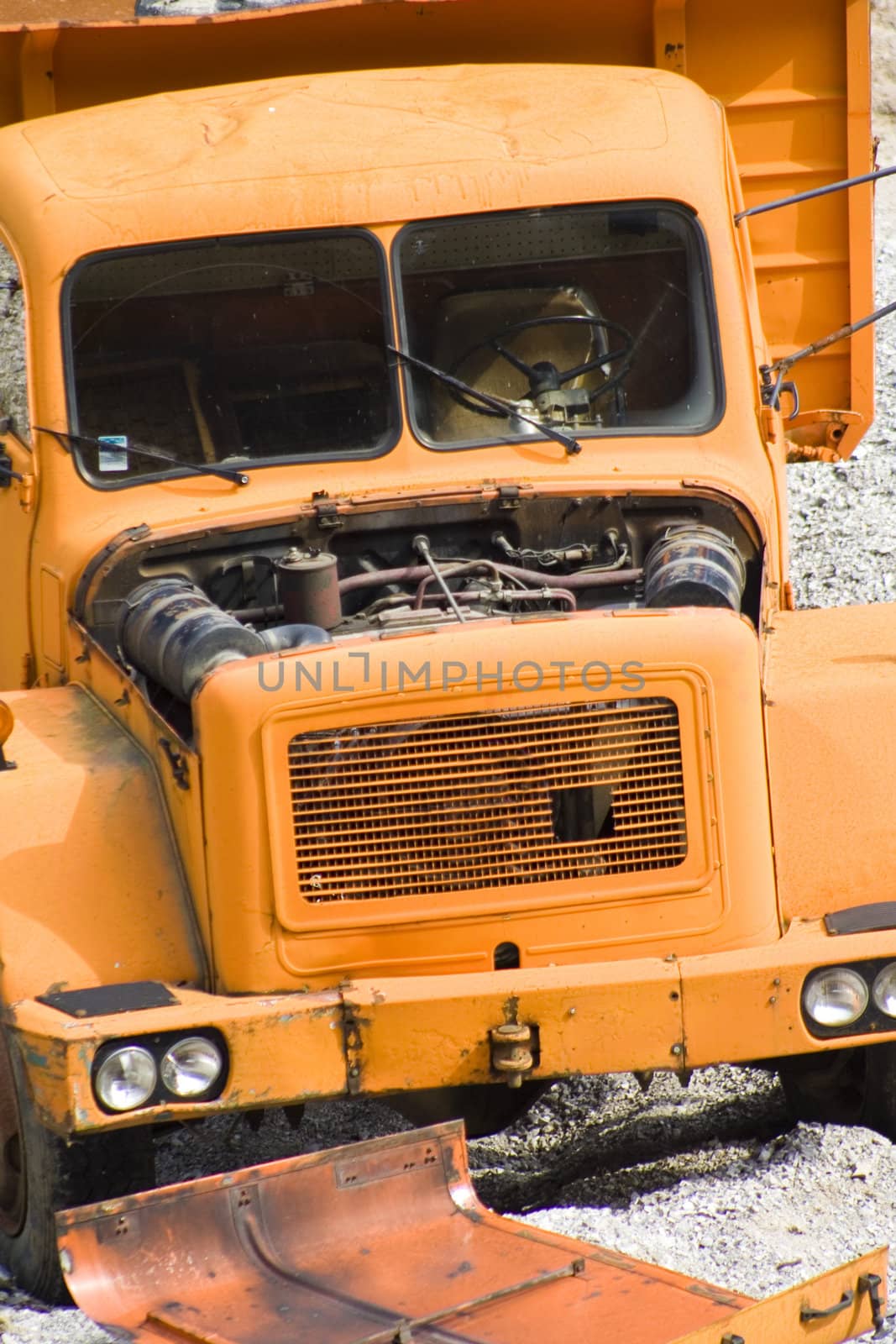 Old, abandoned, broken down orange truck in quarry.