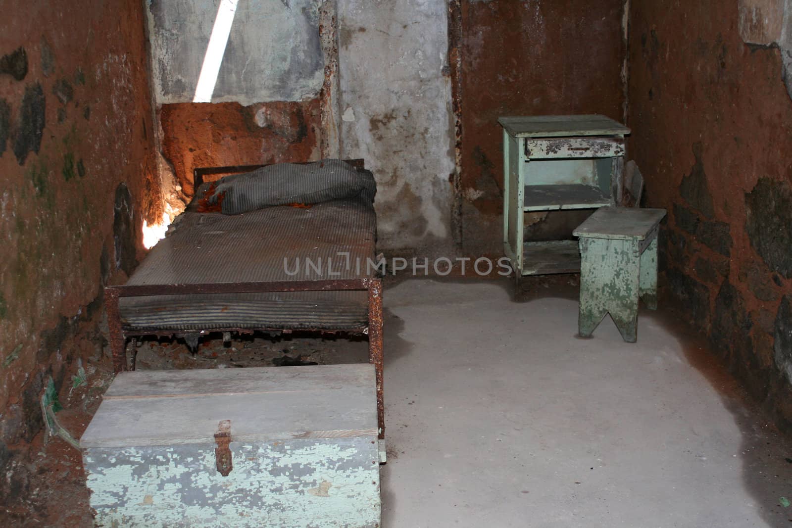 A old prison cell with bed and desk