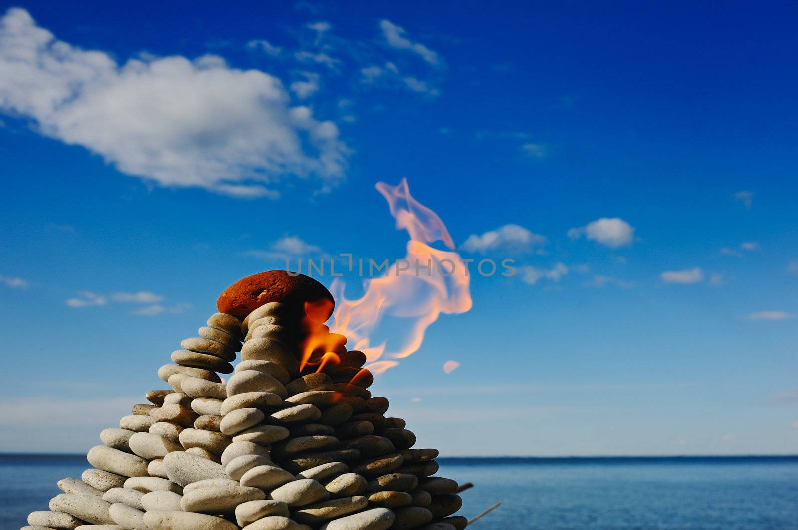 Torch at top of a pyramid from small stones