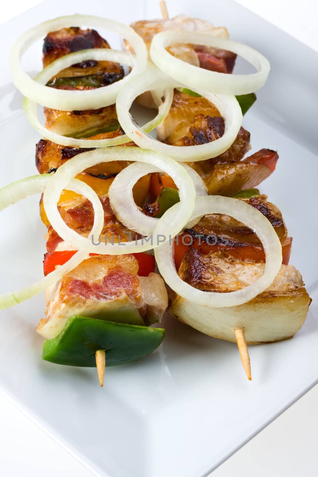 shashlik on a plate with a tomato and salad leaf