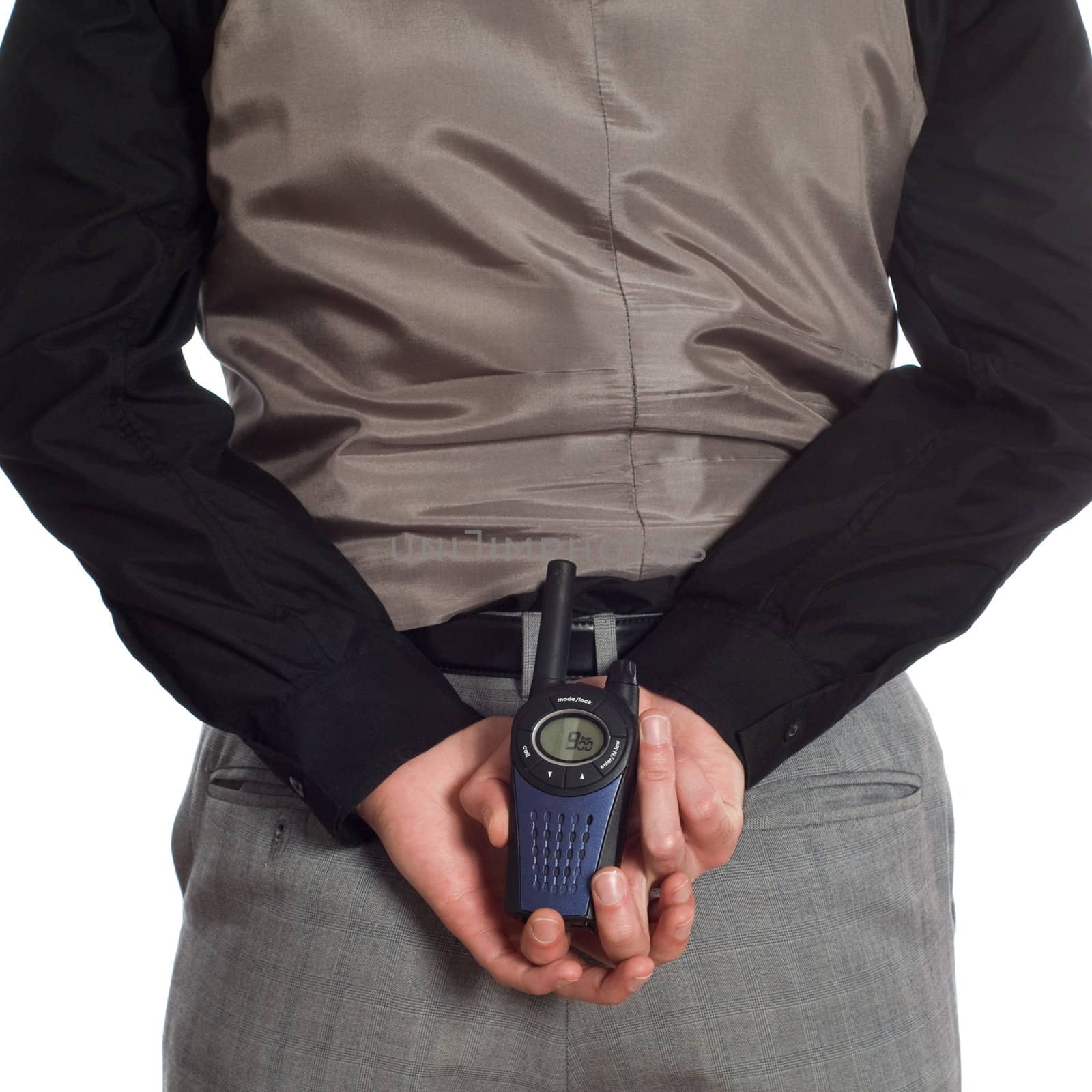 A backside view of a security guard wearing plain clothes, but holding his walkie-talkie behind him, isolated against a white background