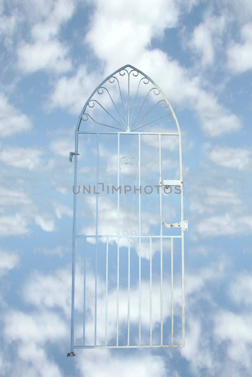 a white wrought iron gate against a cloudy background (with clipping path) depicting heaven