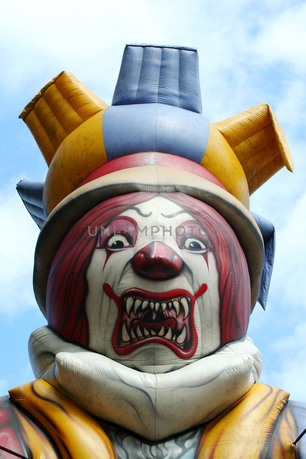 Blow up scary clown against blue sky