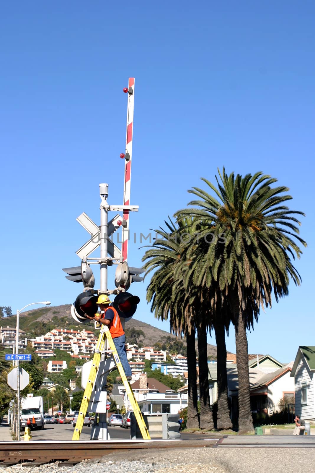 Man cleaning the rail road crossing signals