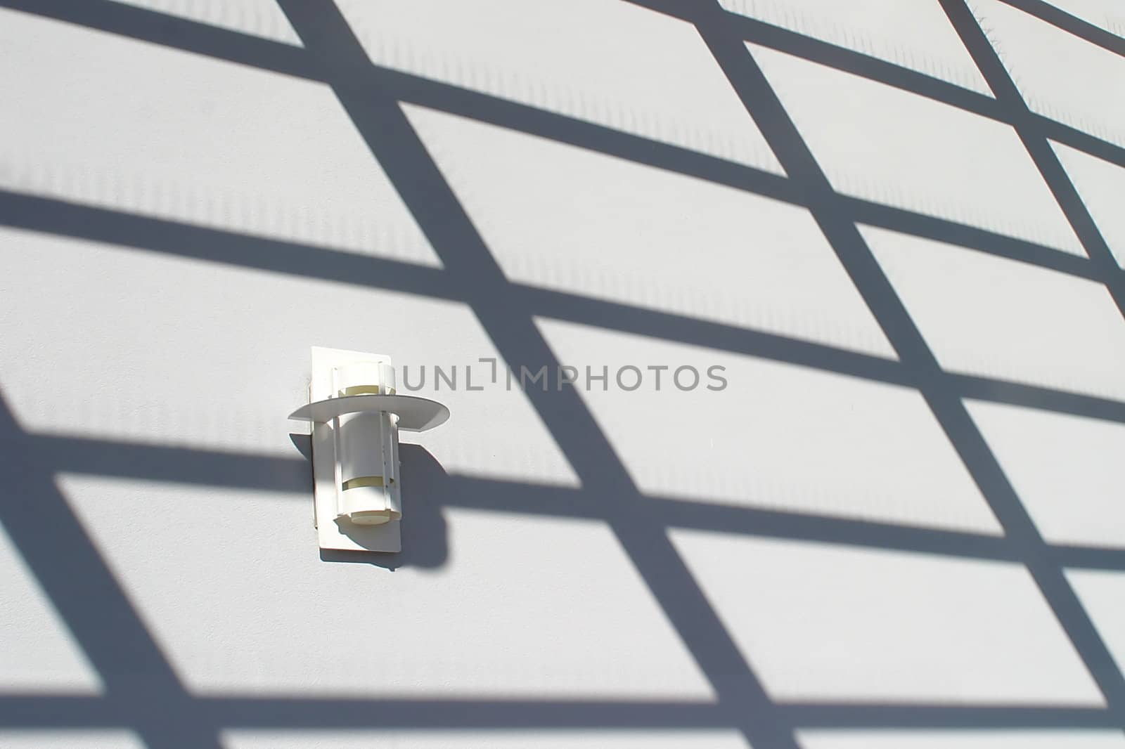 A light on the a wall with shadows that build a design