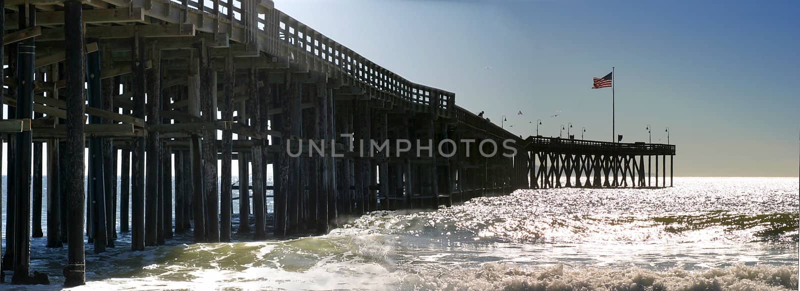 The Ventura Pier with waves and the flag at the end.
