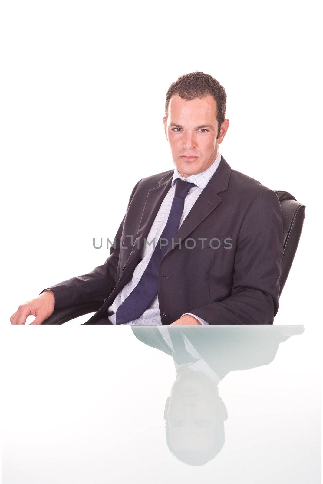 Handsome young confident businessman. On a glass desk, Isolated on white.