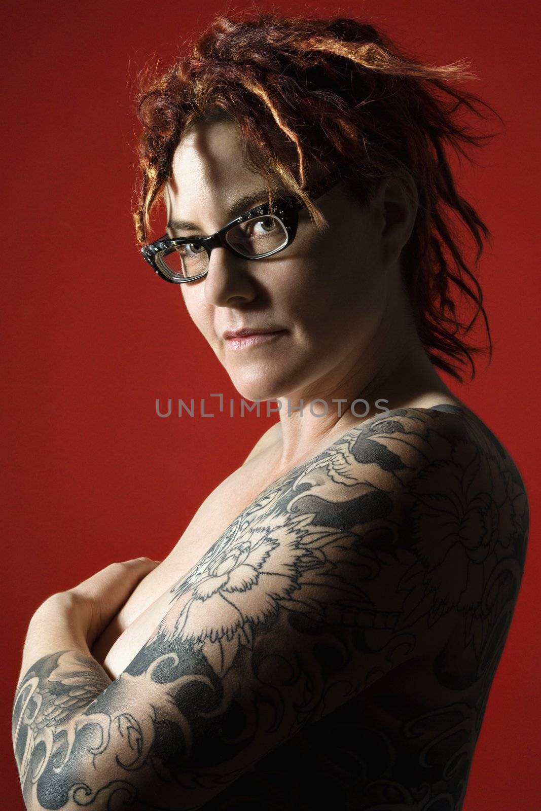 Side view portrait of adult woman with tattoos.