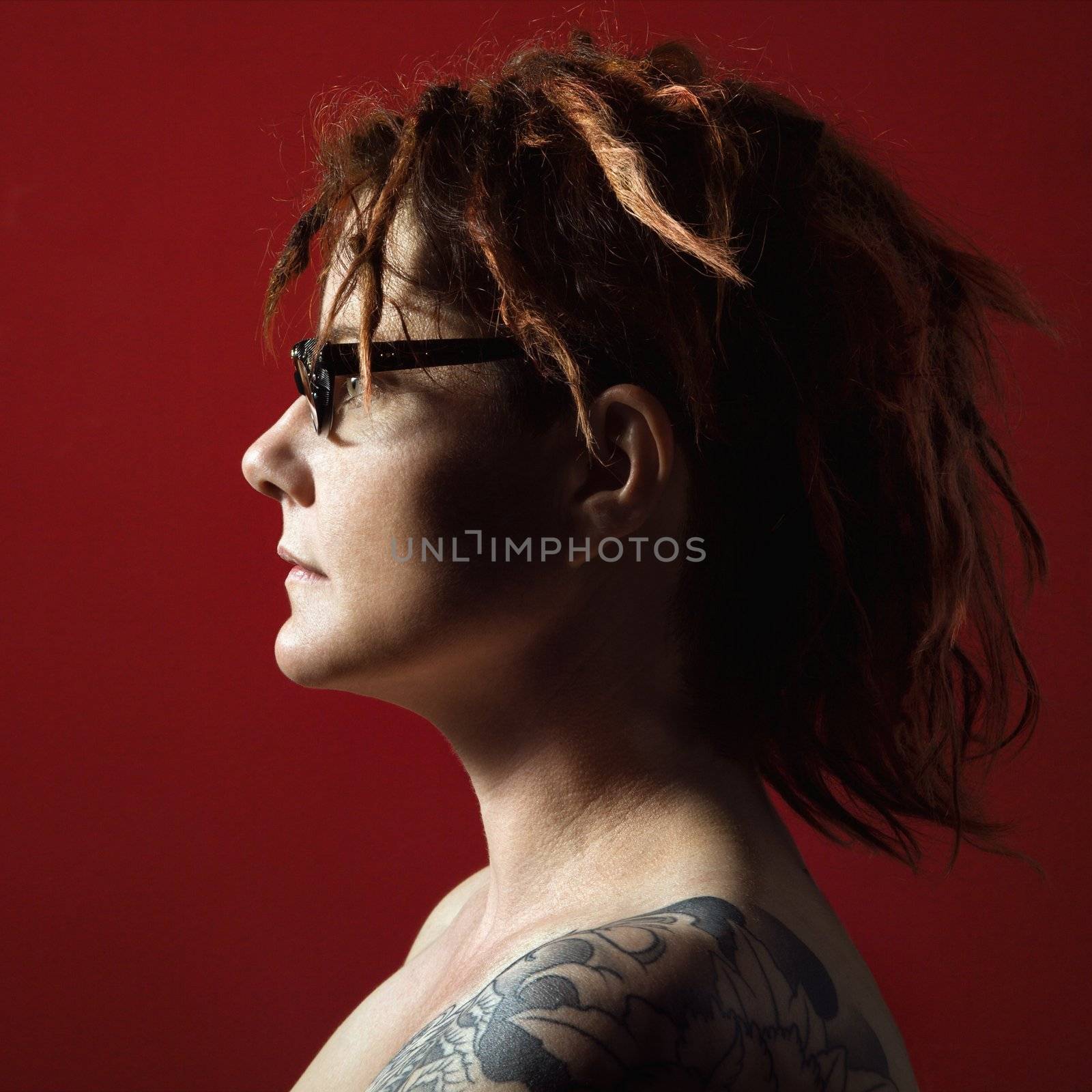 Profile portrait of adult woman with tattoos.