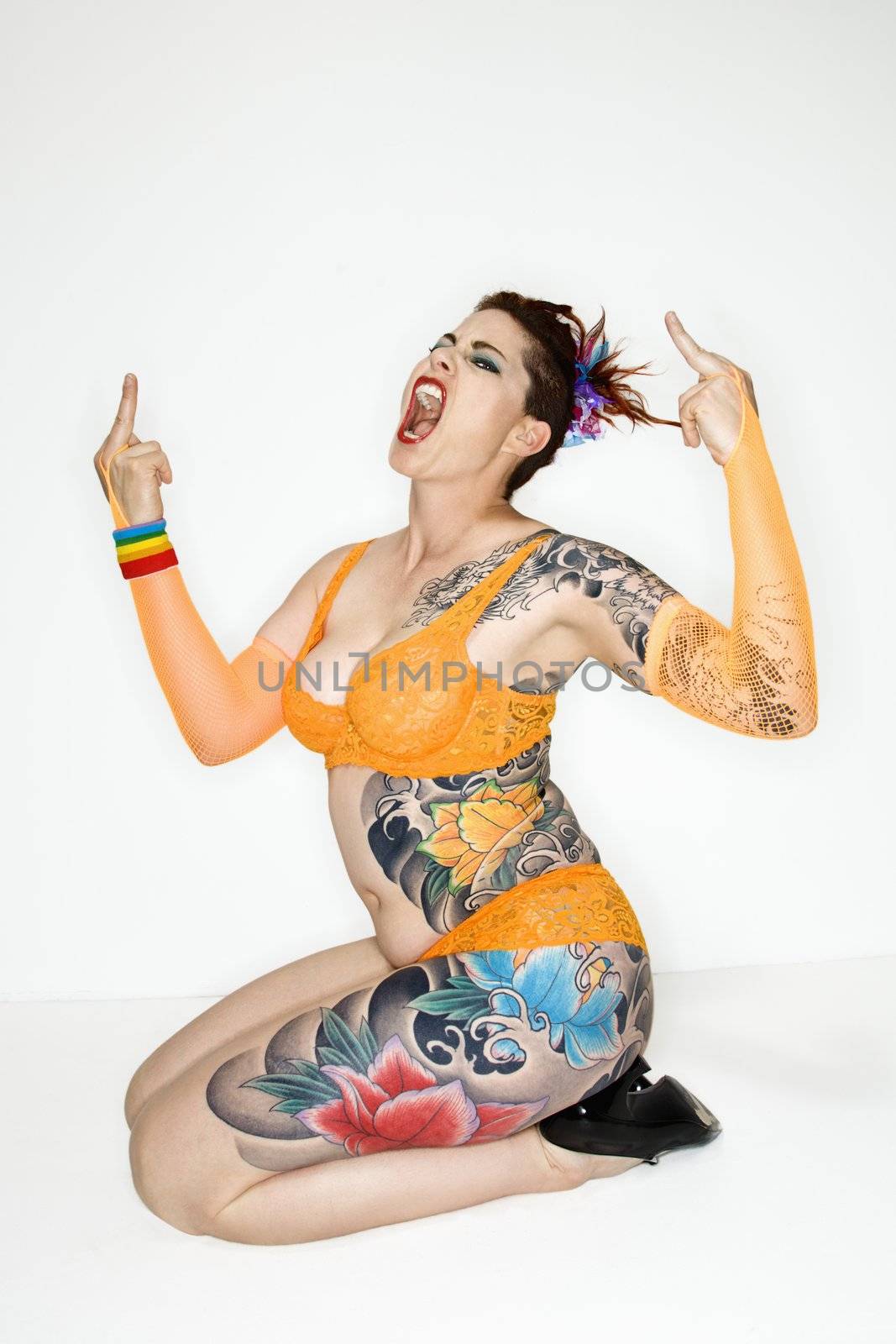 Adult caucasian woman with tattoos making obscene gesture.