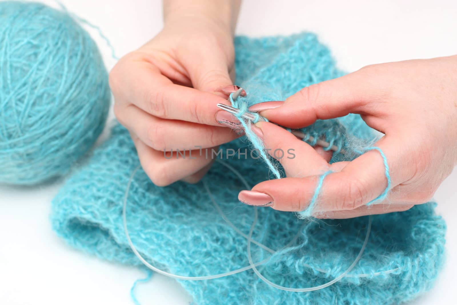 woman hands knitting a turquoise pullover