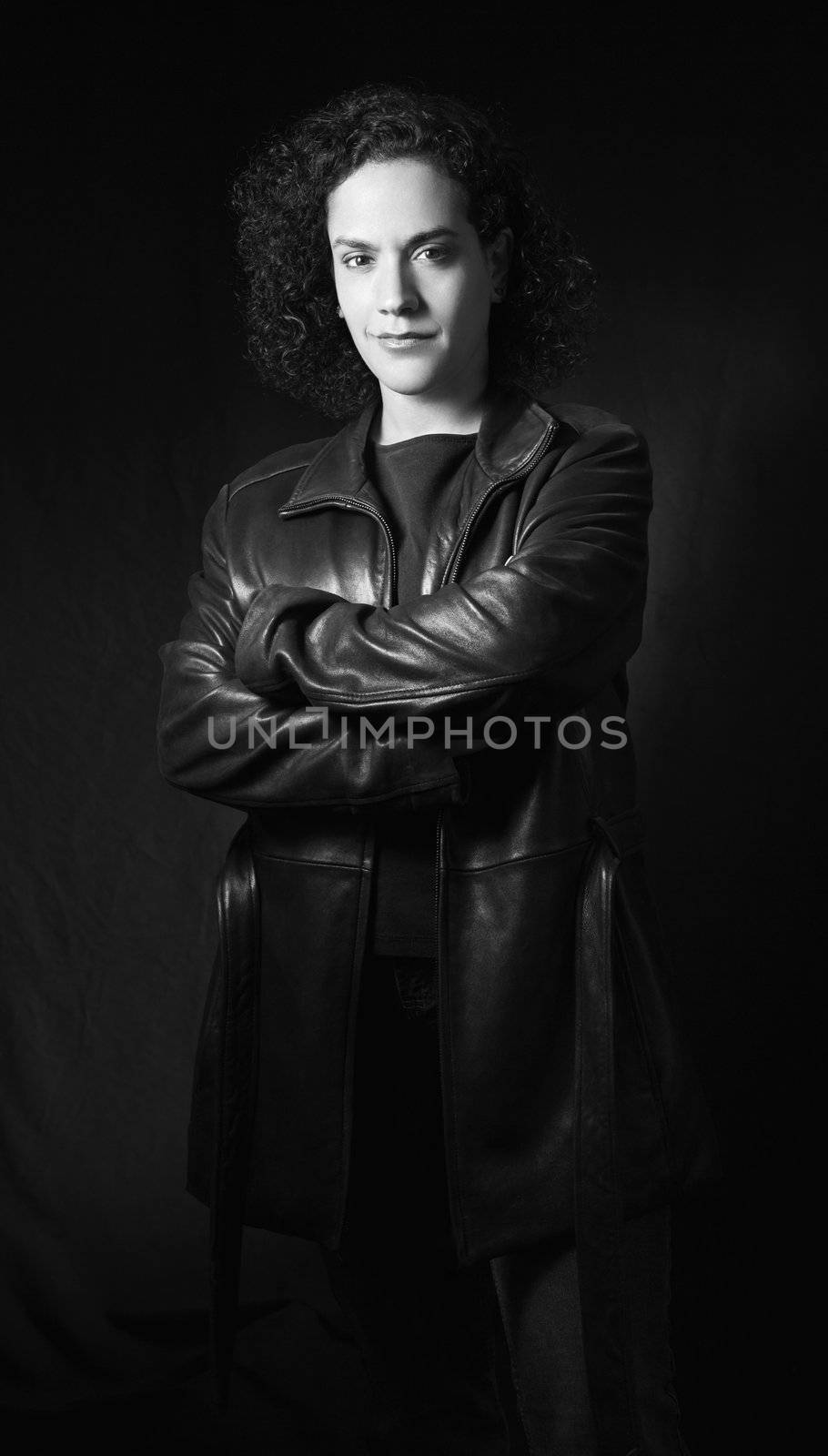 Woman in leather jacket with arms crossed looking at viewer.