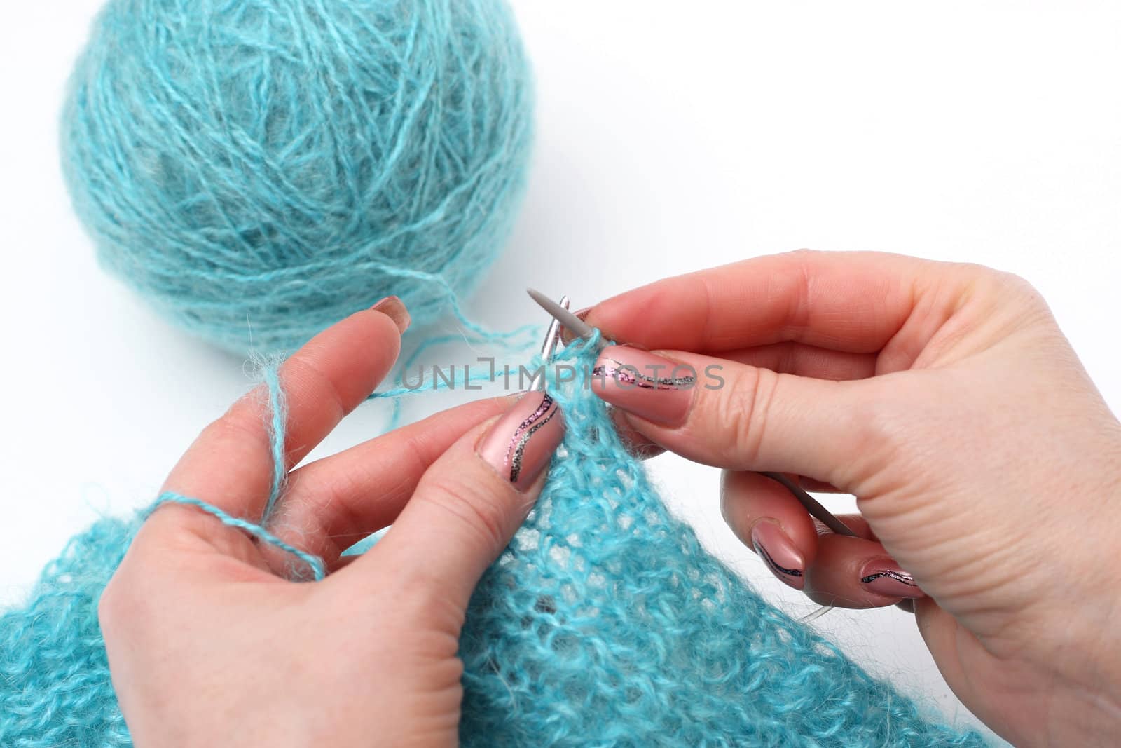 woman hands knitting a turquoise pullover