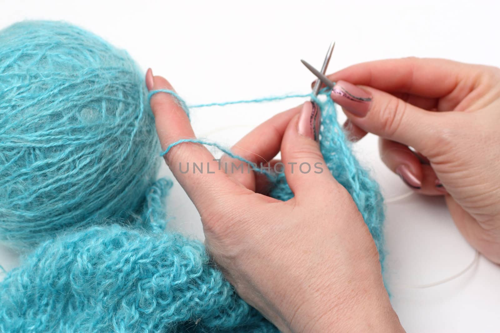 woman hands knitting a turquoise pullover