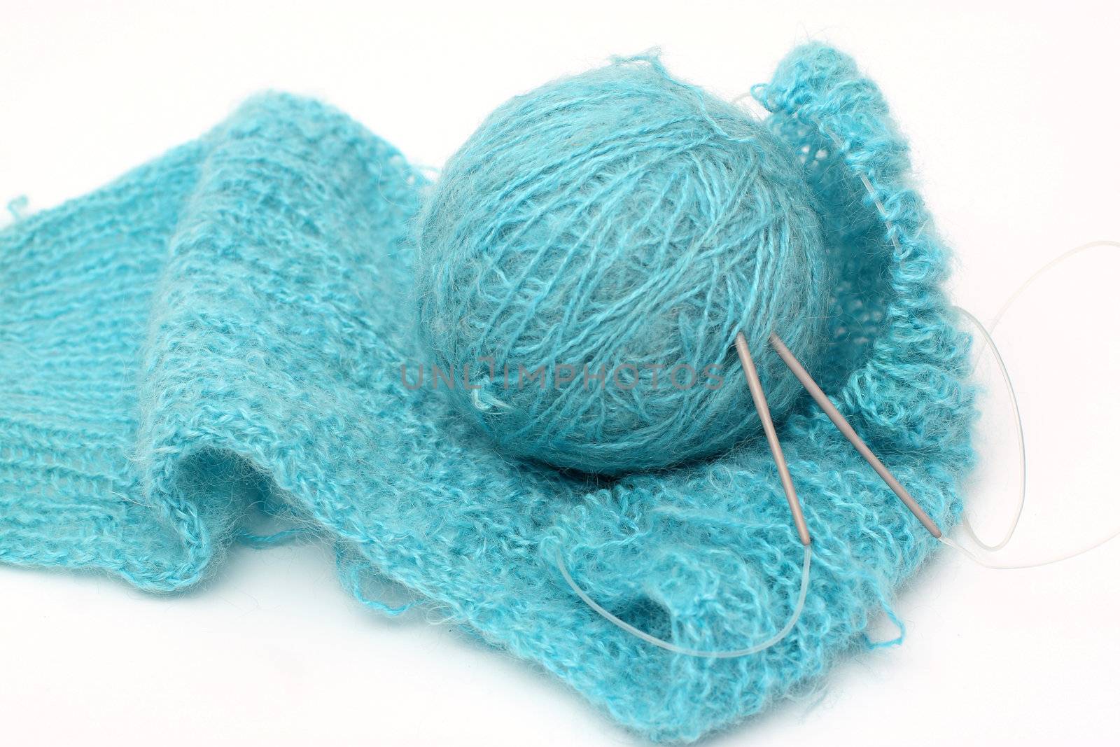 knitting a turquoise pullover and ball of a turquoise yarn
