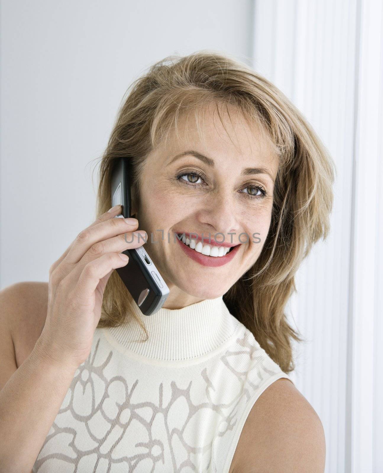 Caucasian woman smiling on cellphone.