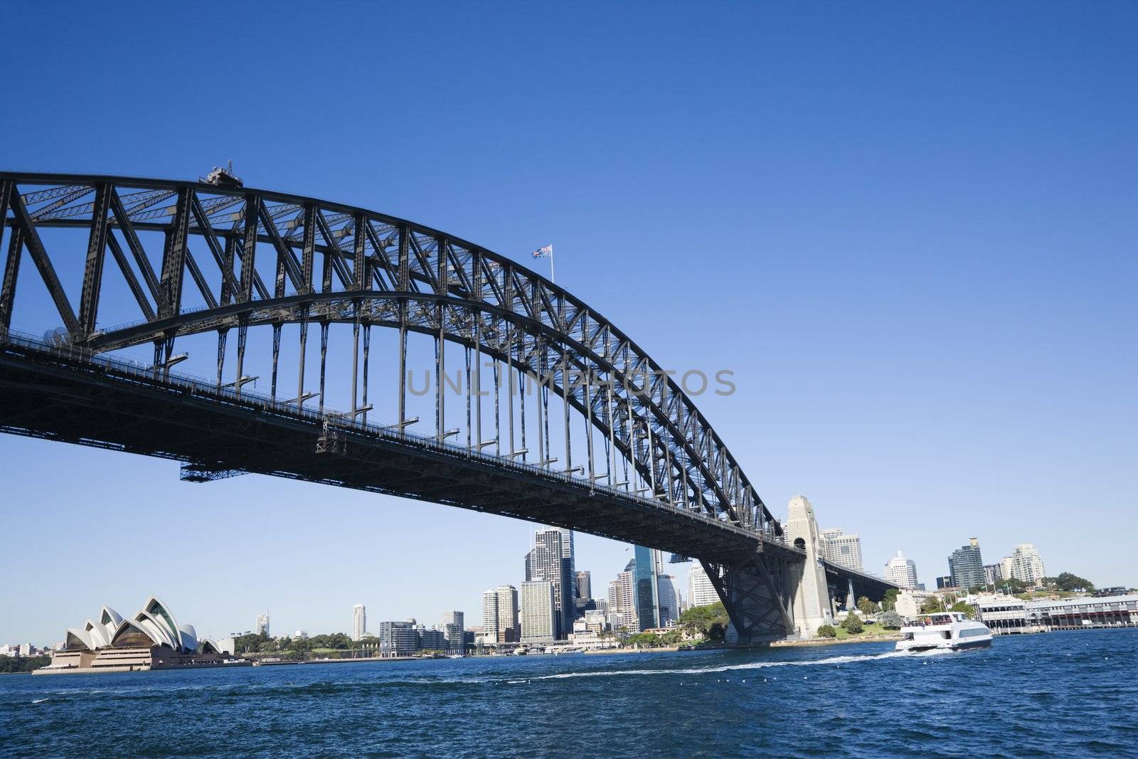 Sydney Harbour Bridge with view of downtown buildings and Sydney Opera House in Australia.