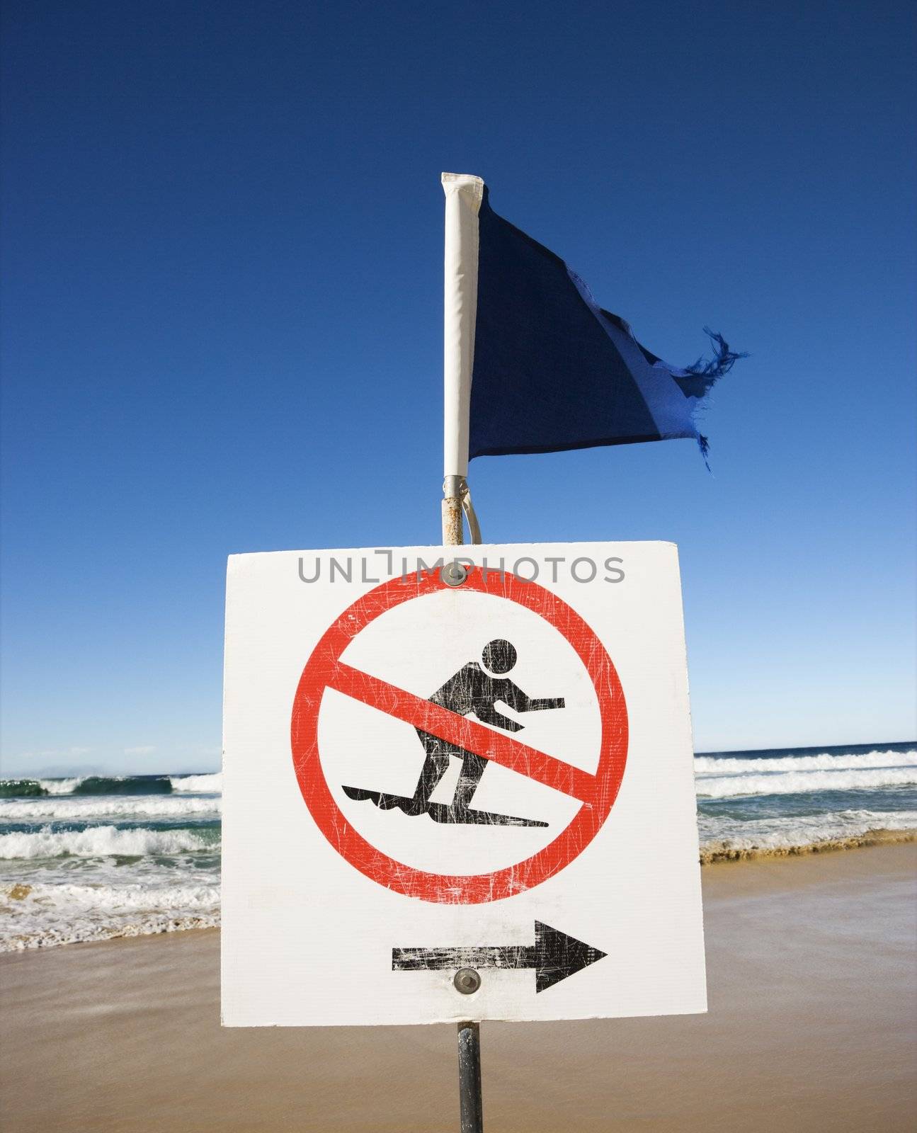 No surfing sign and flag on beach at Surfers Paradise, Australia.