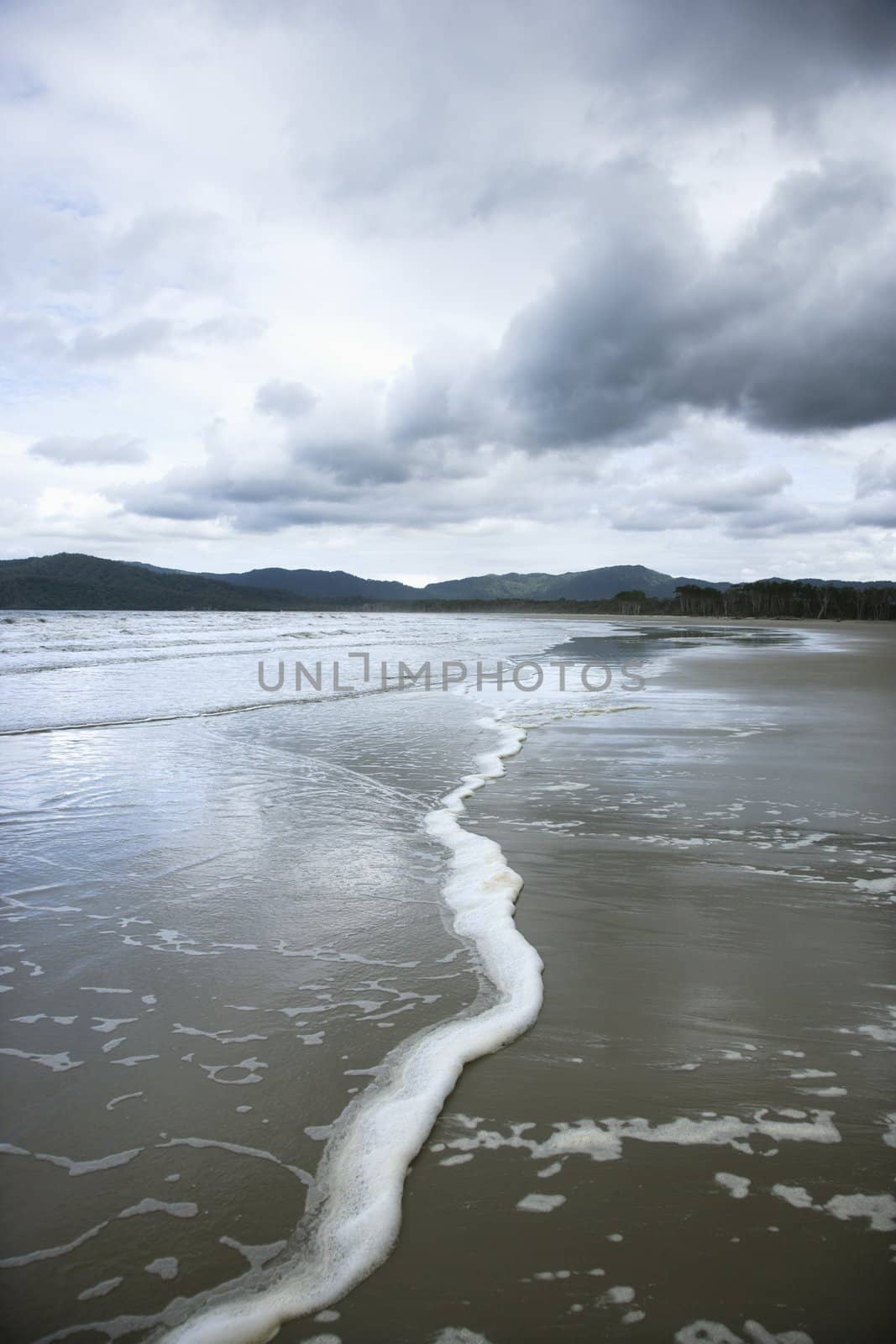 Ocean with distant mountains and cloudy sky in Daintree Rainforest, Australia.