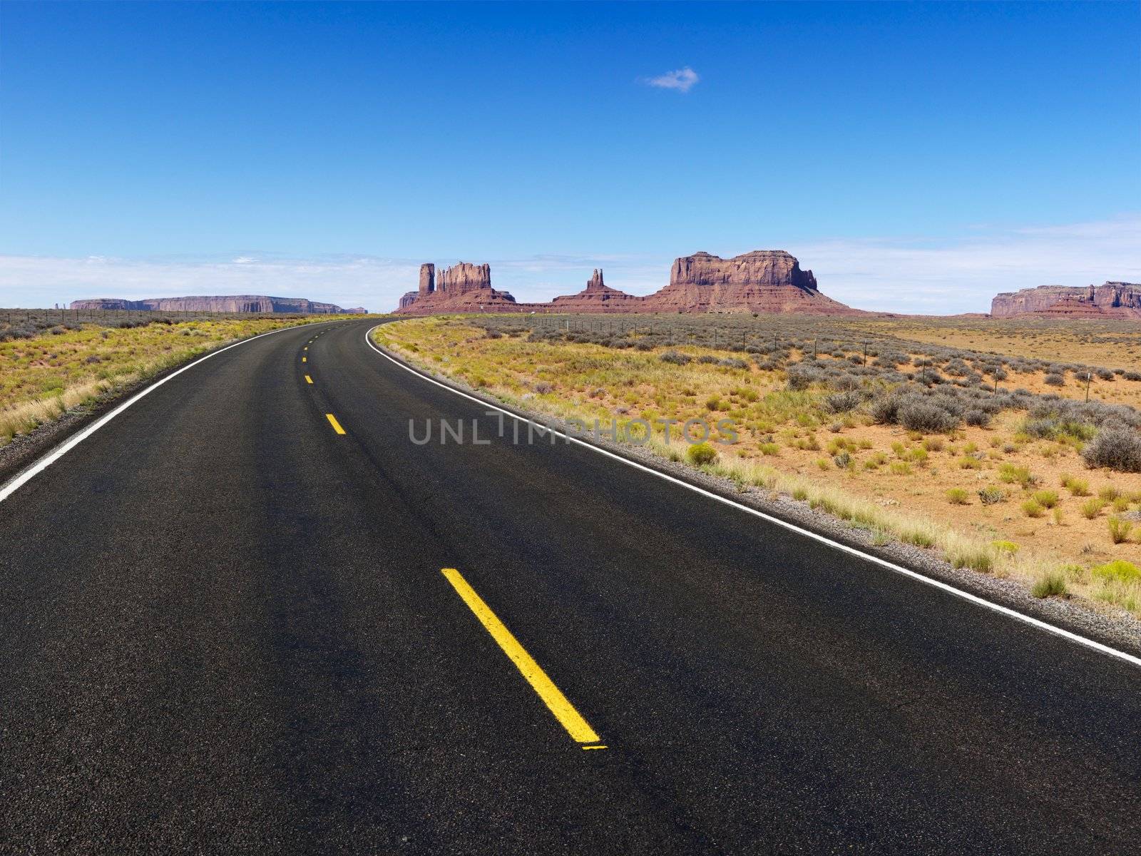 Remote desert road with mountain land formations.