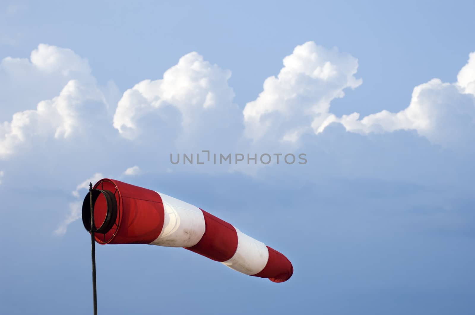 Windsock close-up against the blue sky with clouds