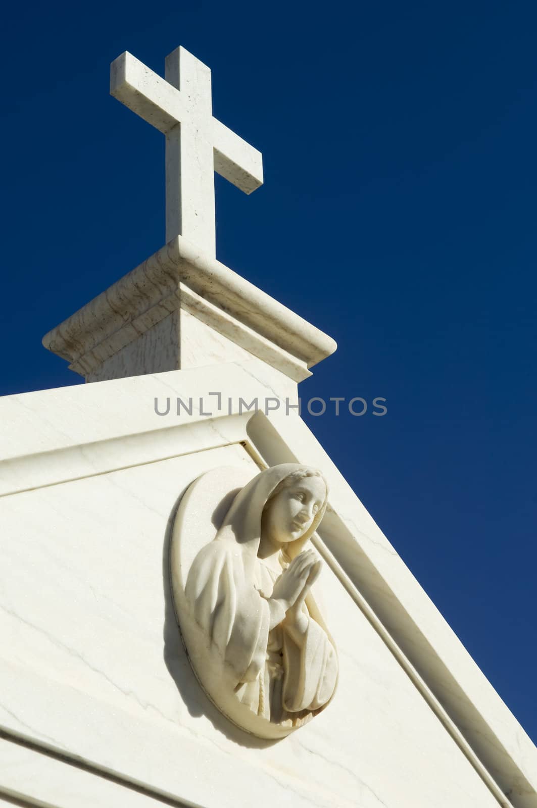 Cemetery mausoleum detail showing a saint praying