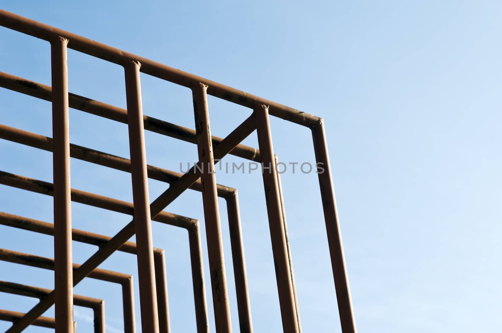 Rusty cage detail painted in red against the sky