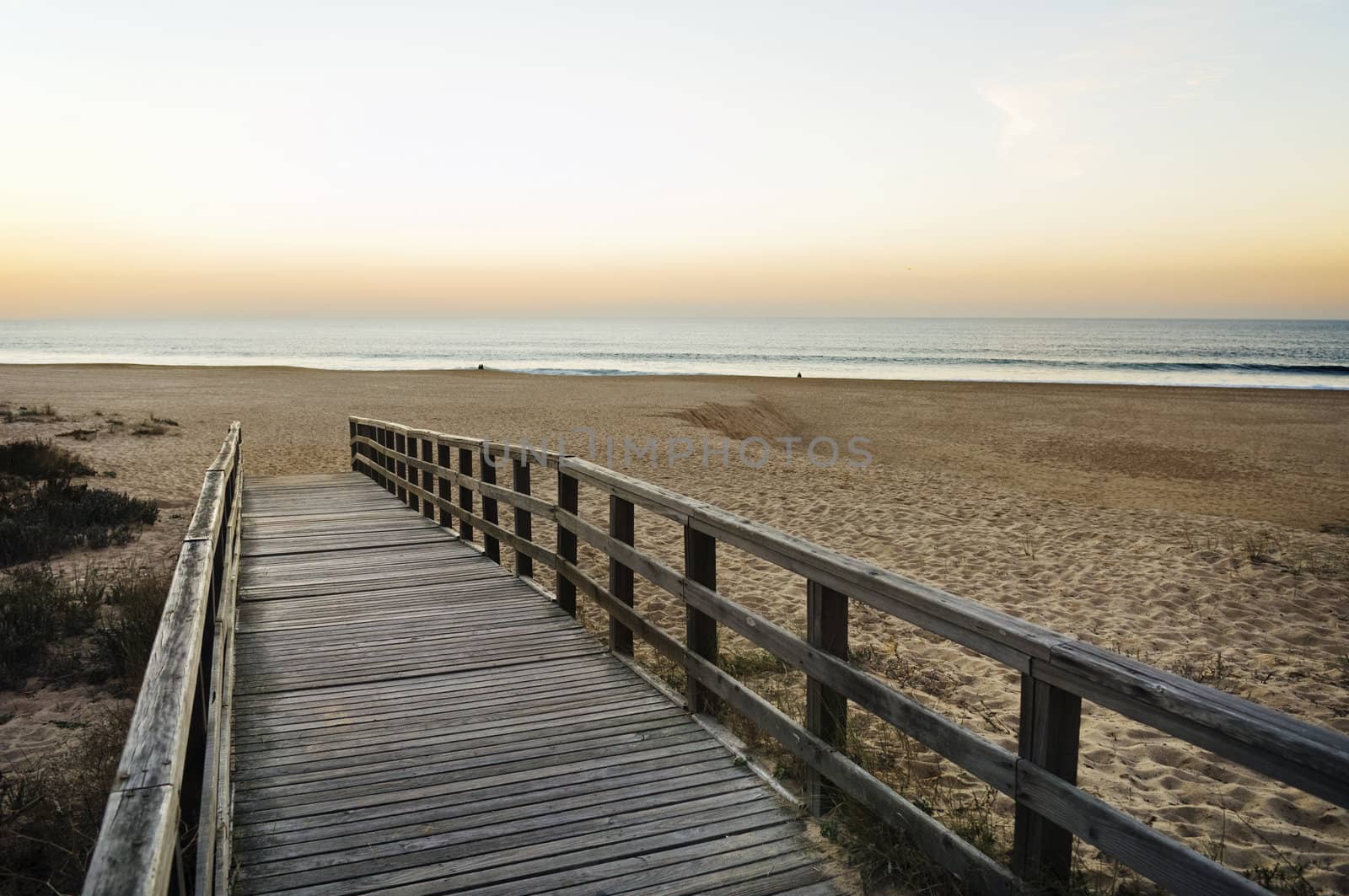 Wooden footbridge leading to the empty beach 