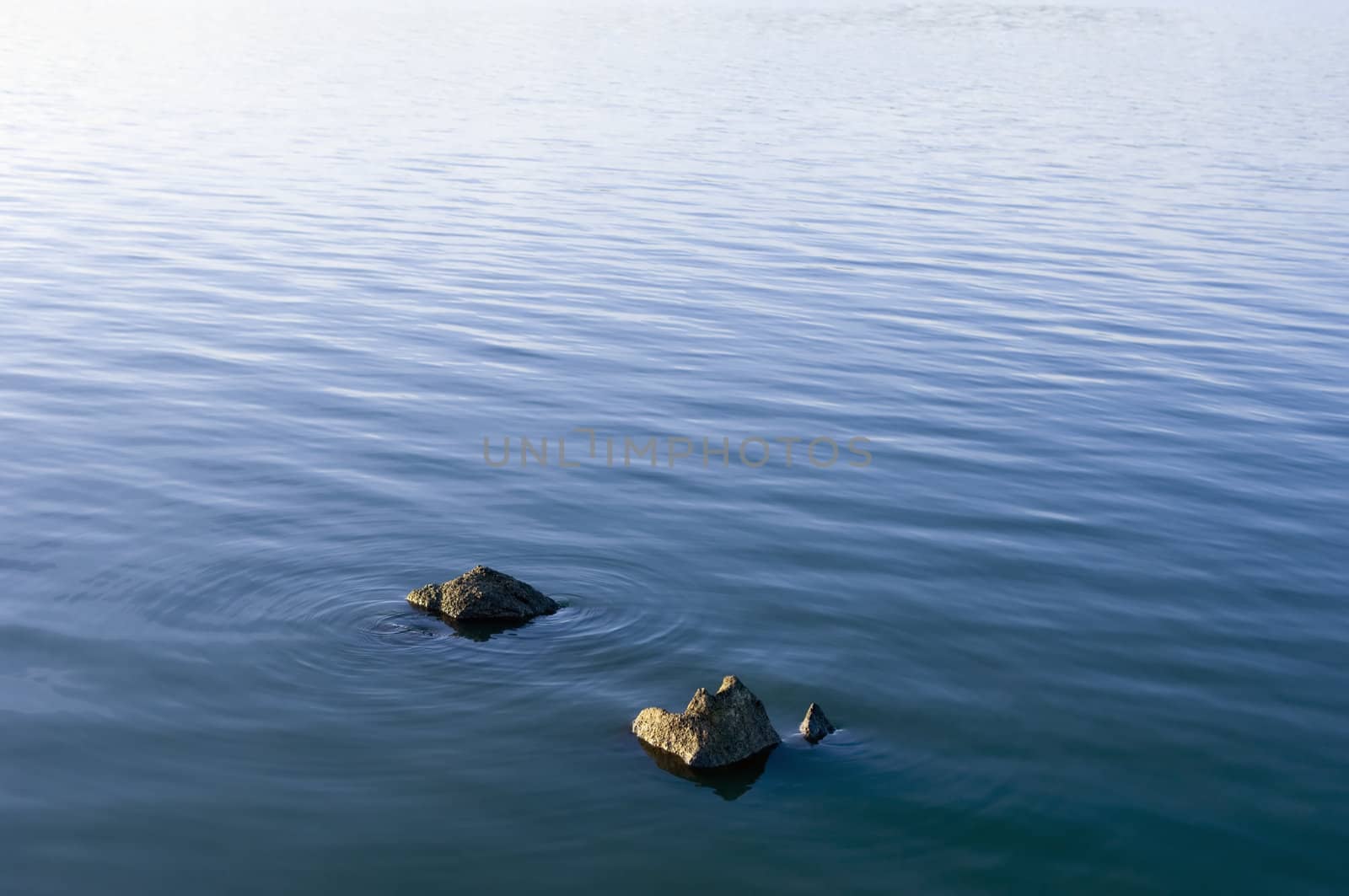 Stones emerging from a beautiful smooth water surface 