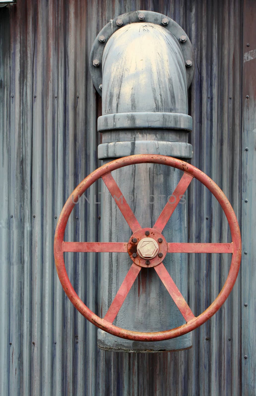 A Large red wheel valve with pipe