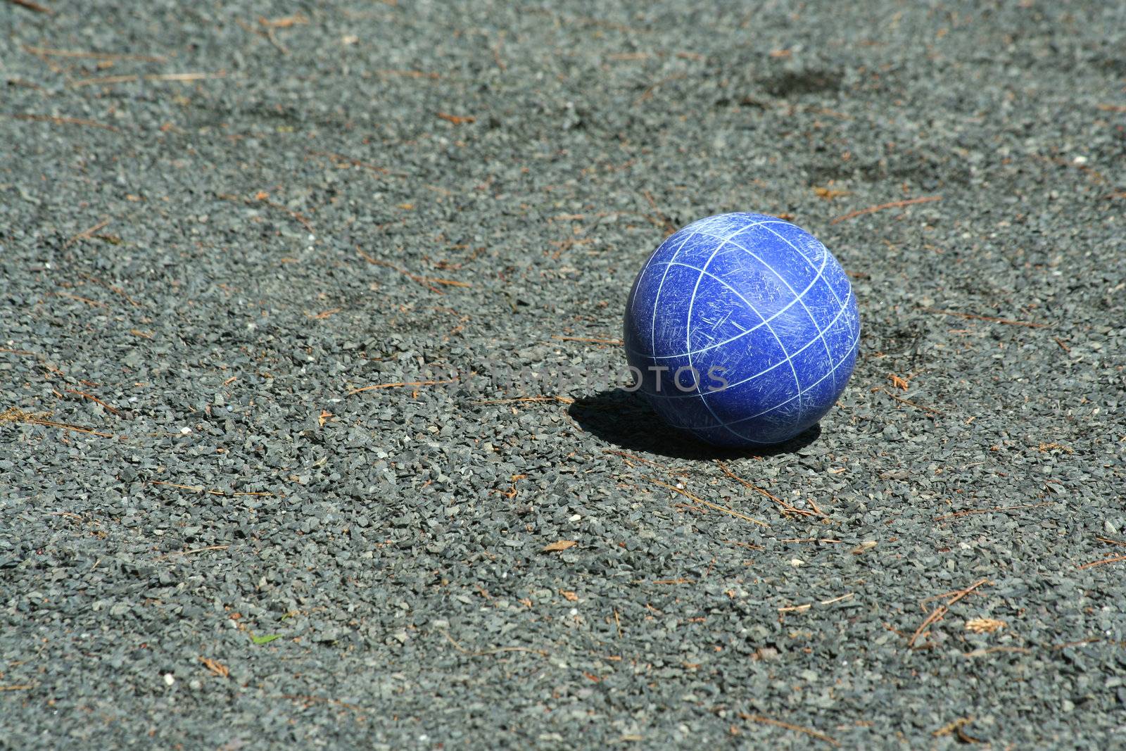 A Blue bocce ball on a court