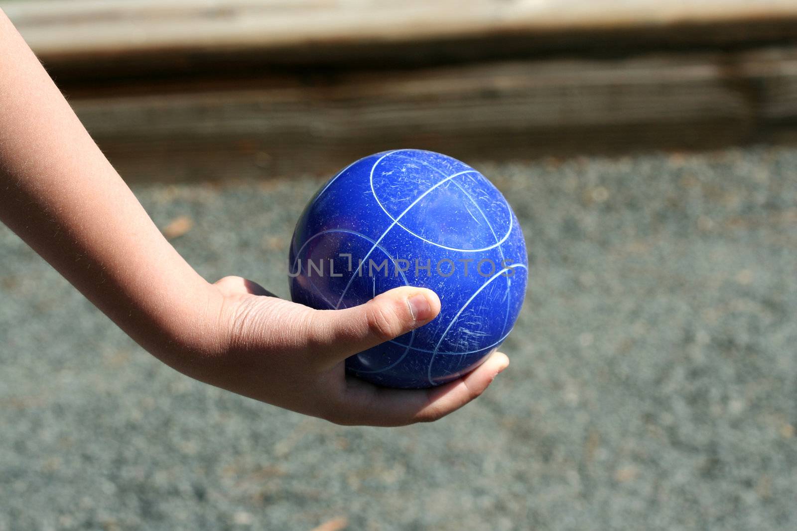 A Hand holding a blue bocce ball