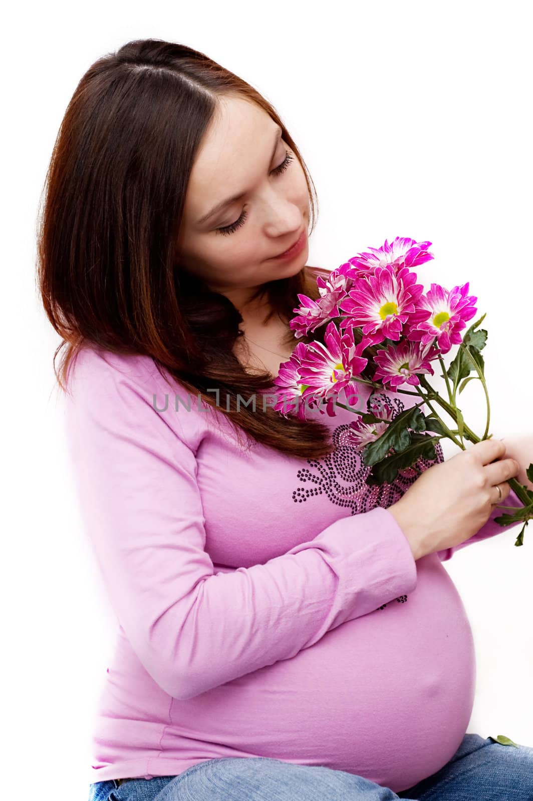 Beautiful pregnant woman holding belly with flowers