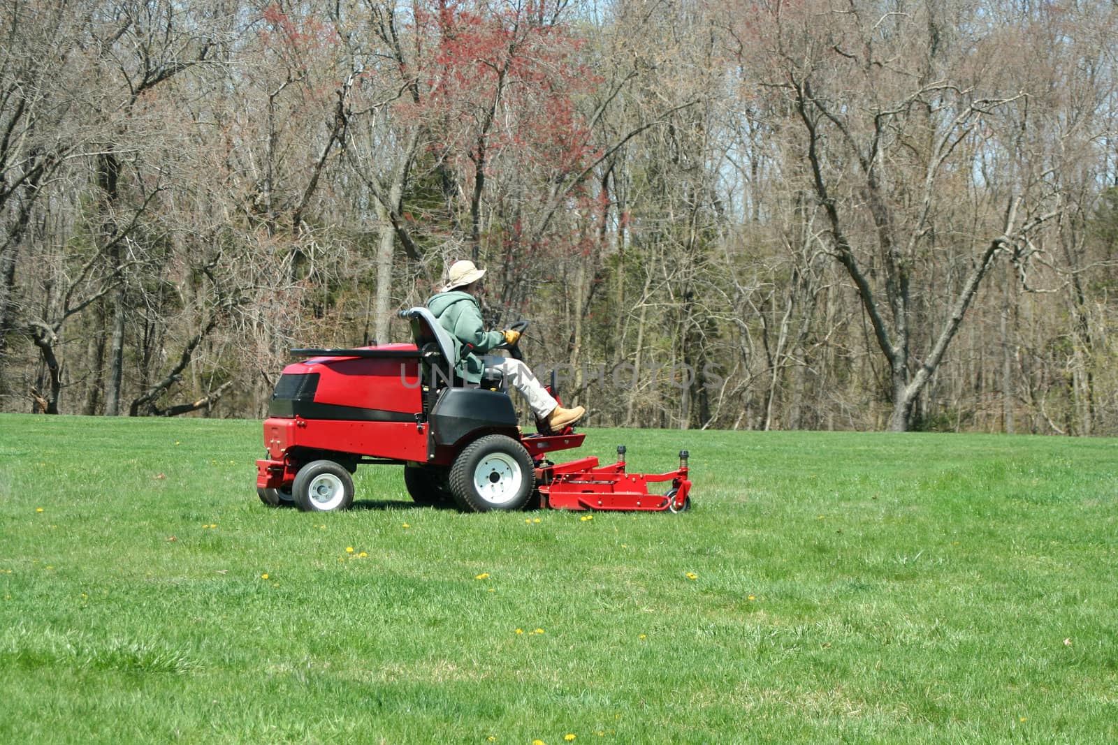 A Person cutting the lawn on a riding mower