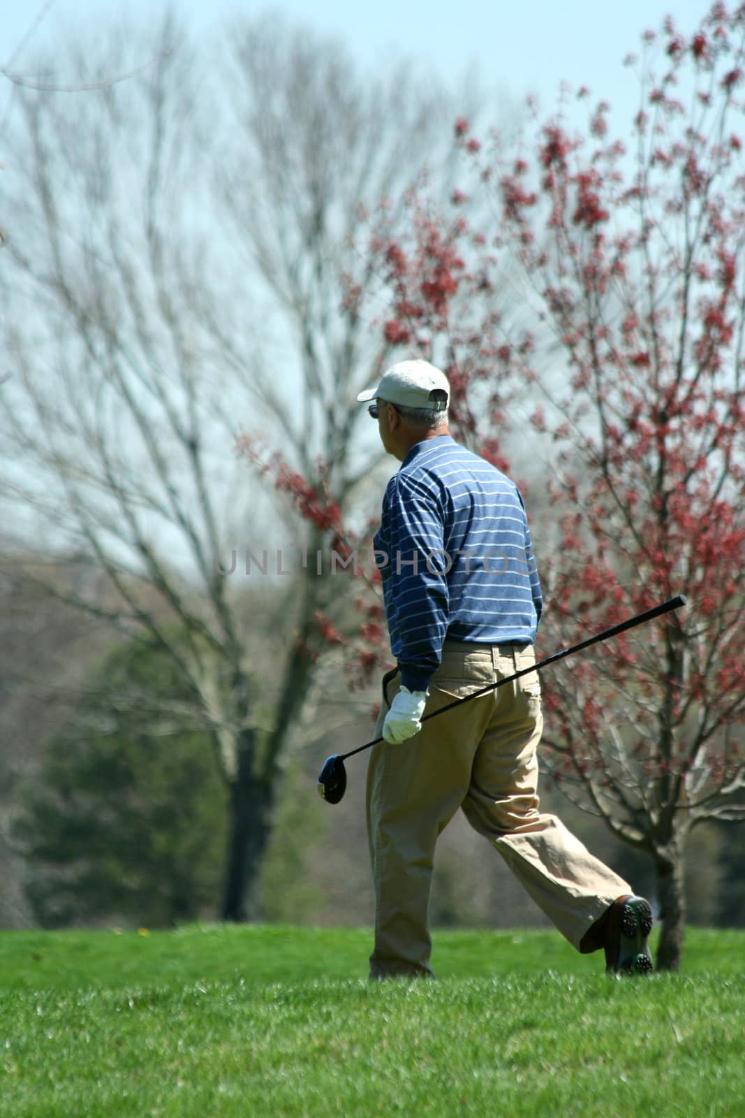A Male golfer walking on a golf course