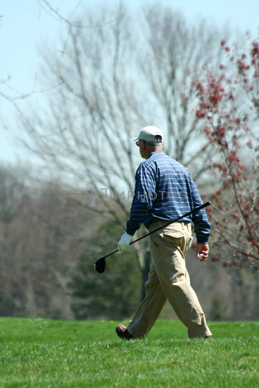 A Male golfer walking on a golf course